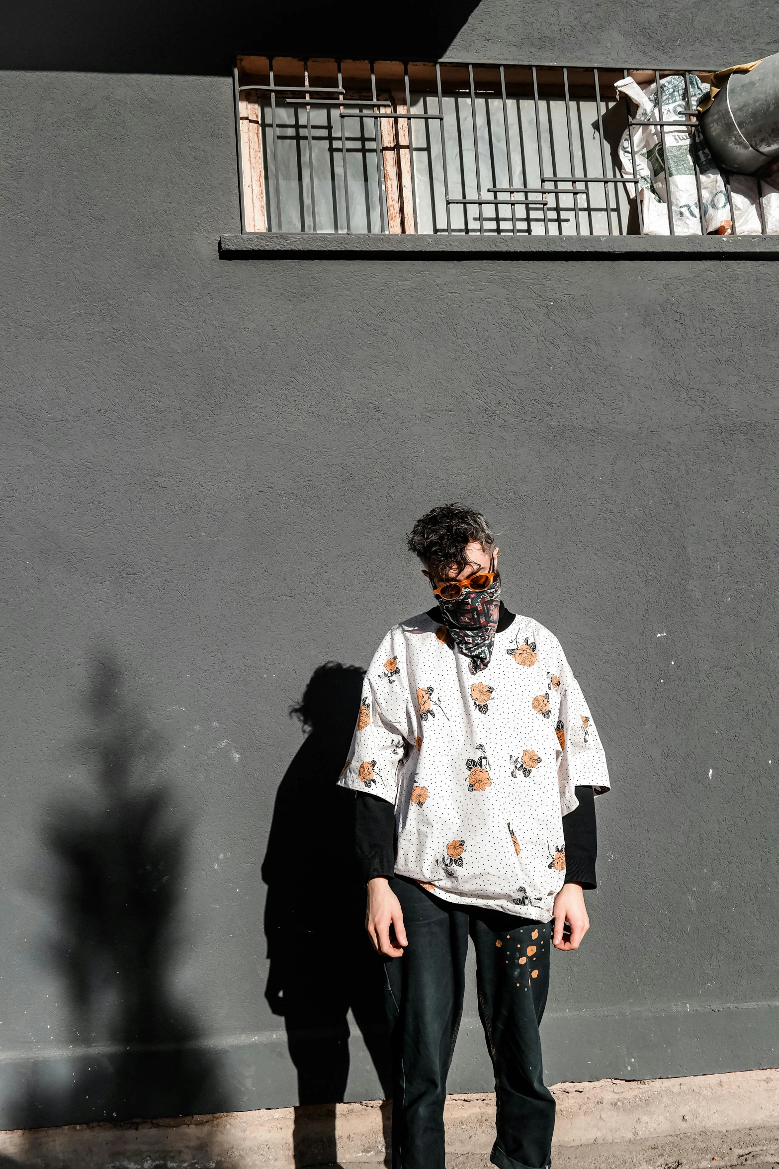 a man is standing by the wall wearing an elephant scarf