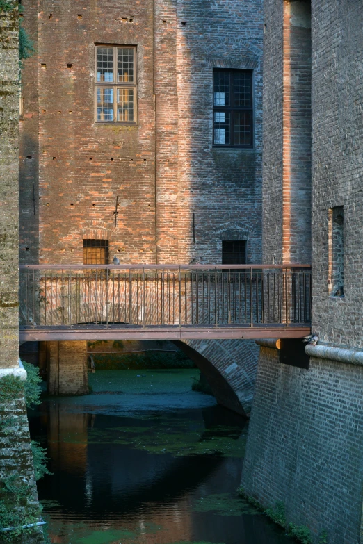 a bridge over a small stream near buildings