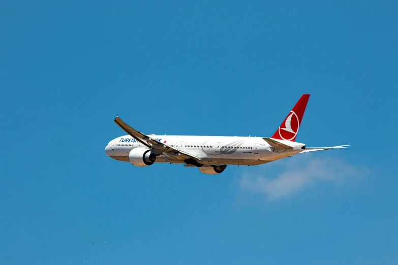 there is a large white and red airplane flying in the sky