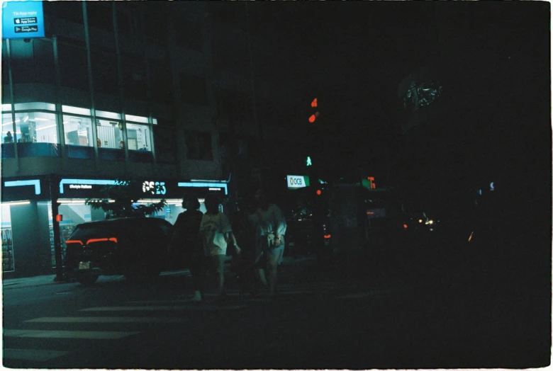 a night view of the city street with cars parked outside