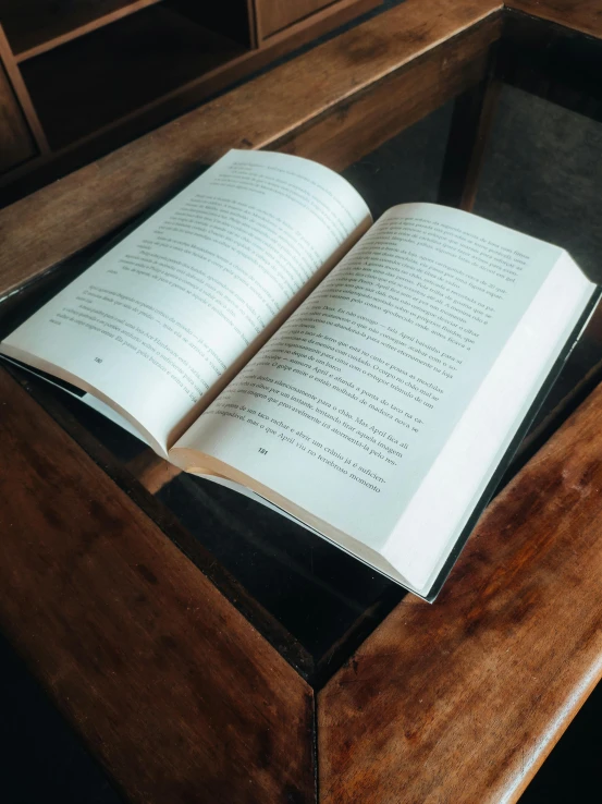 open book sitting on the end of a wooden desk