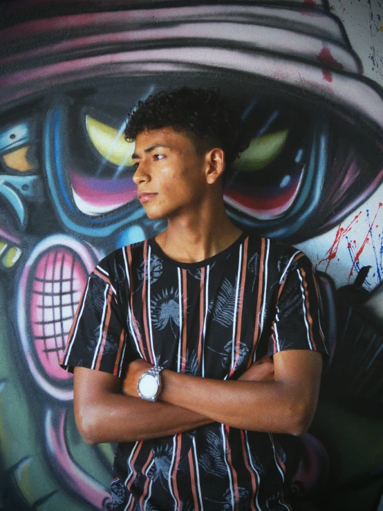 a guy standing in front of a wall covered with graffiti