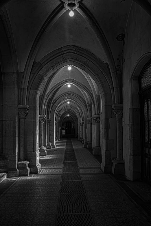 a dark walkway with several benches lined up against it