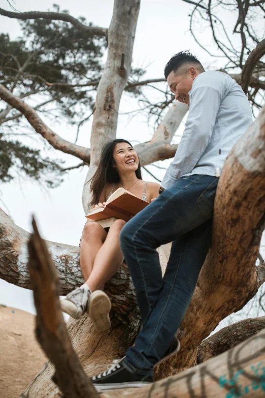 a man and woman sitting on the nches of a tree