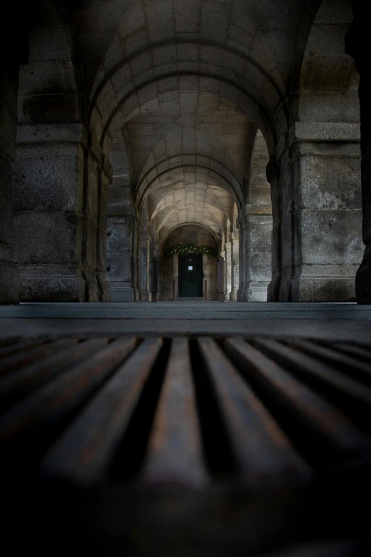 a wooden bench sitting in the middle of a long hallway