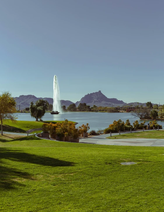 a scenic view of a water fountain and some hills