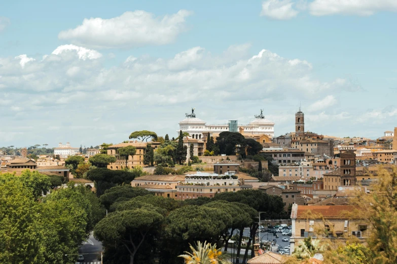 the view of an old european town with trees and clouds