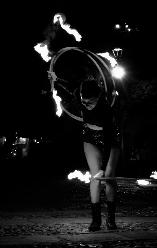 a girl spinning a fire hoop outside in the dark