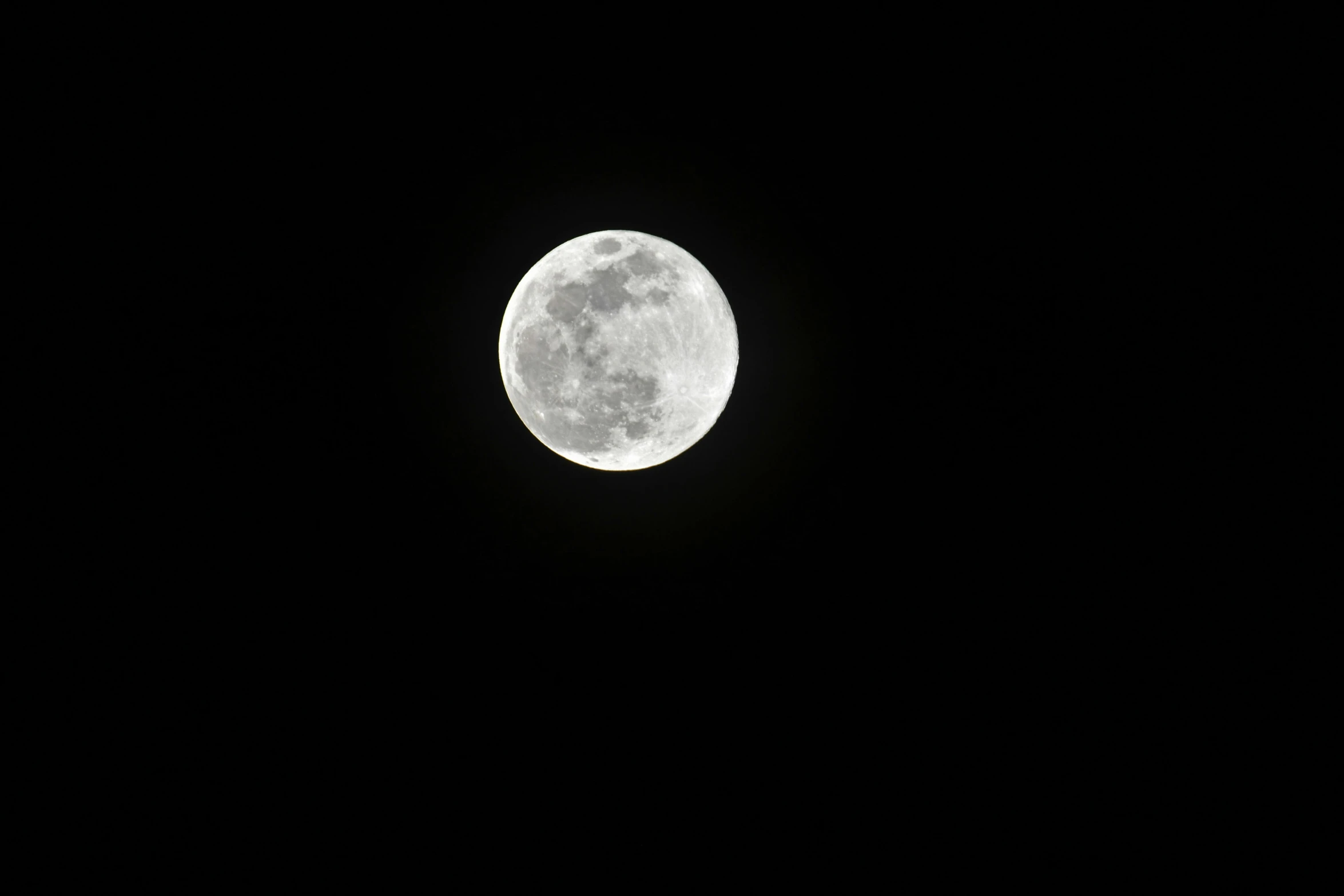 a full moon shining through the night sky