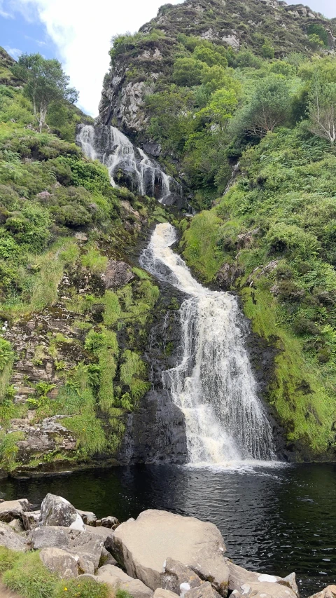 the waterfall in the forest is tall and tall