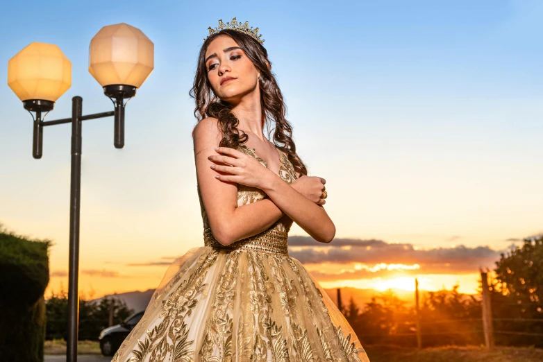 a woman dressed in a gown standing near a lamp post