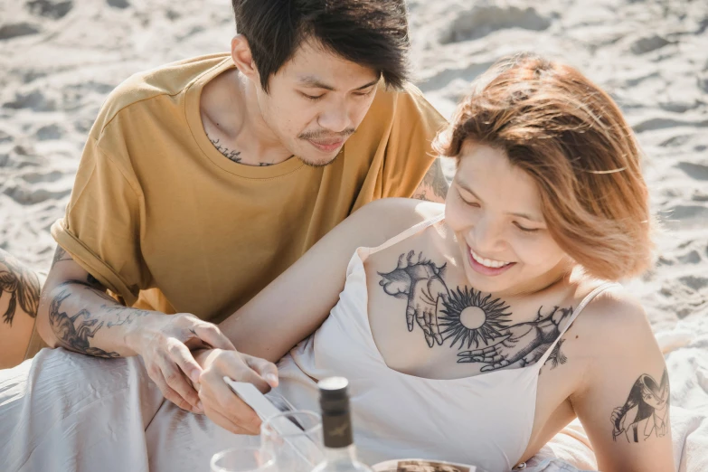 a tattooed man and woman looking at a phone