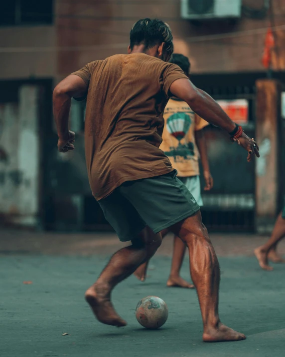 a man is kicking a soccer ball on the street