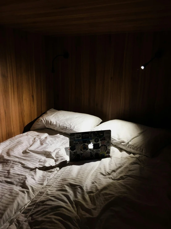 a bed with a laptop that is turned on