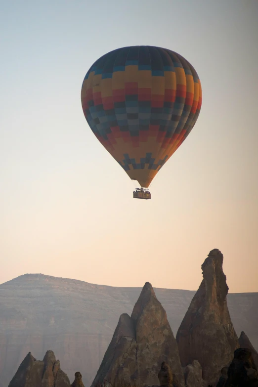 an air balloon that is flying over some mountains