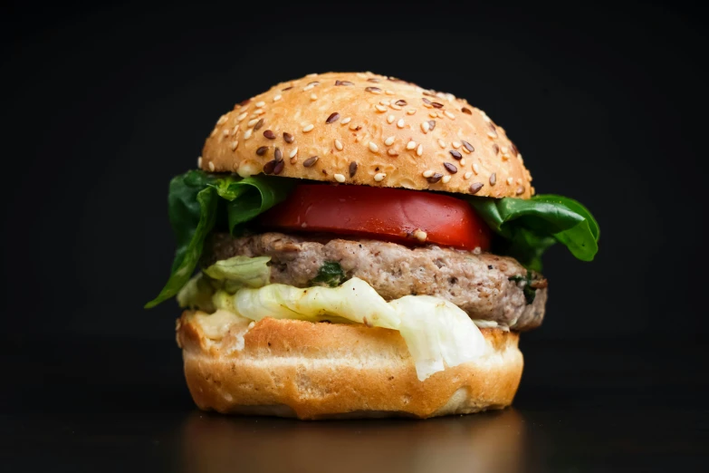 an extremely large hamburger with tomatoes, lettuce and onions