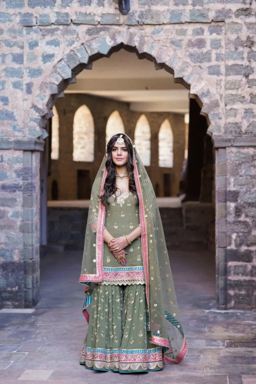 an indian bride wearing a green bridal dress