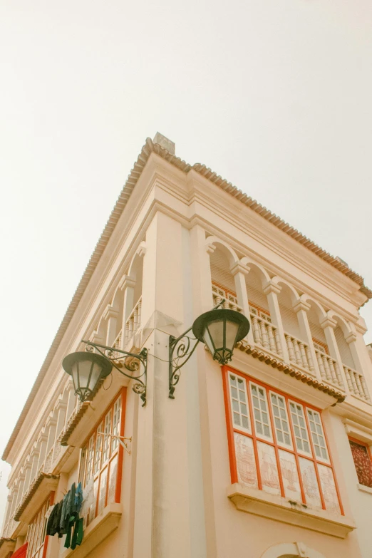 an old, vintage building has orange and white windows