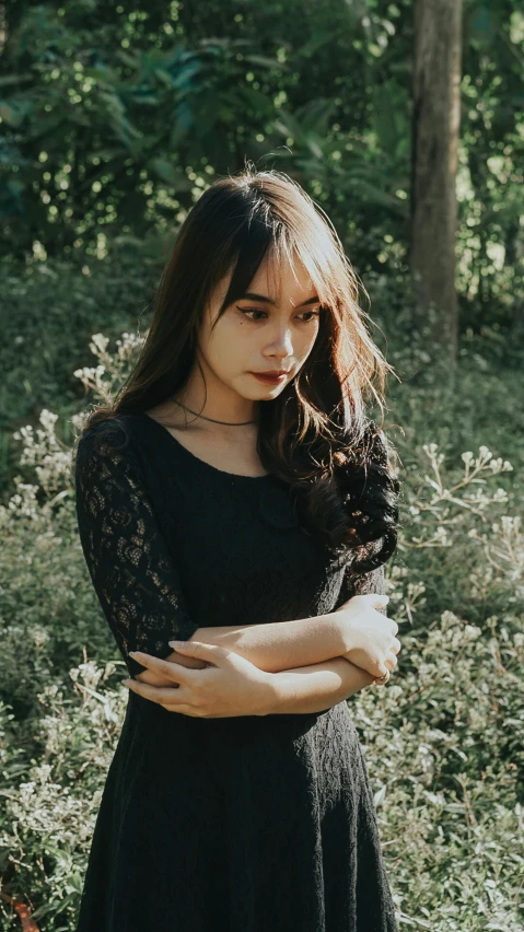 a beautiful woman standing in a field near flowers