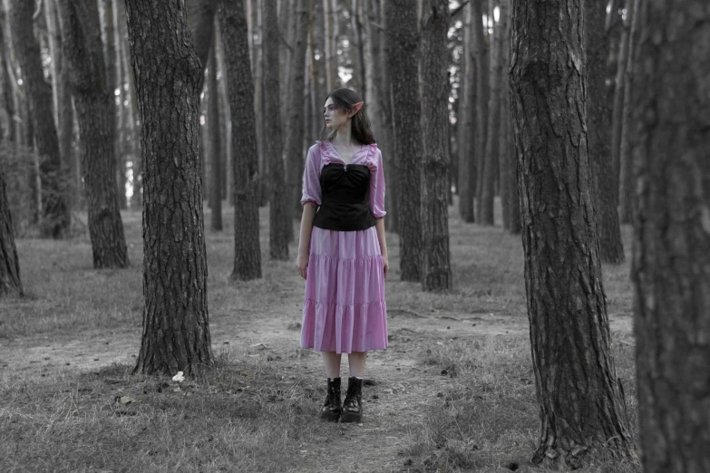there is a woman in a pink dress and boots in the woods