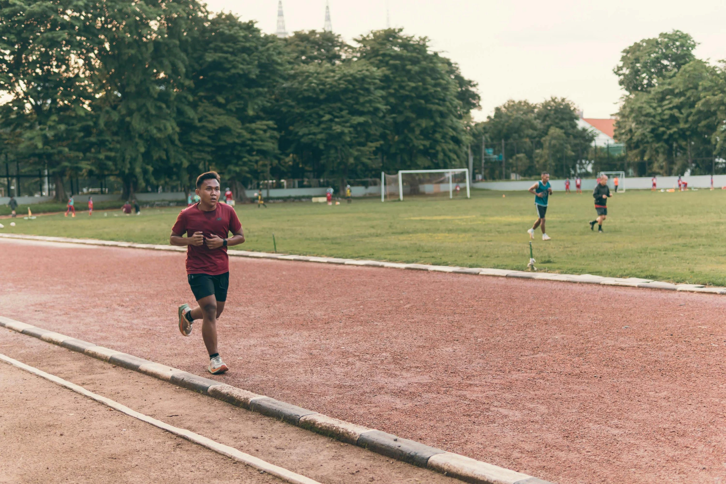 the boy in a maroon shirt is running across the road