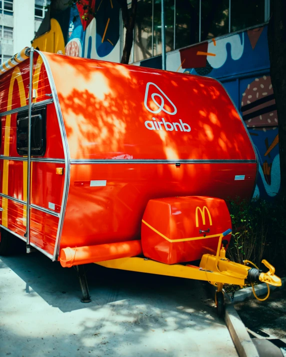 an orange mcdonalds food cart parked next to a building