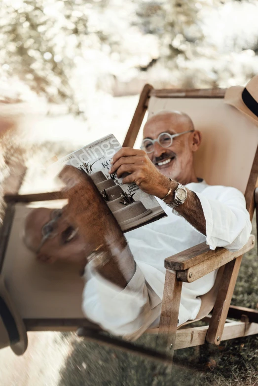 a person sitting in a chair holding up a book