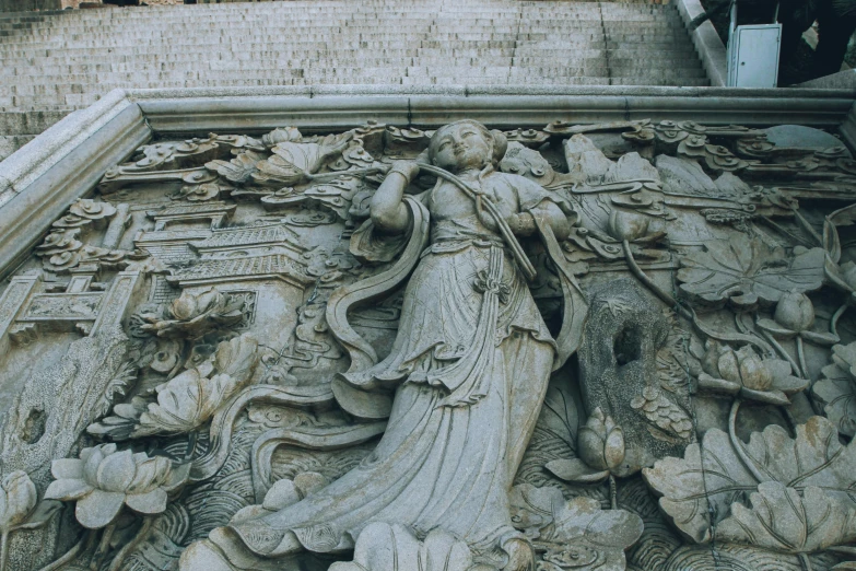 an architecturally designed wall features a woman holding a rose