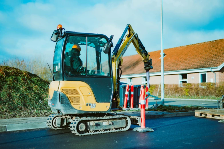 a yellow bulldozer parked next to the road on some pavement