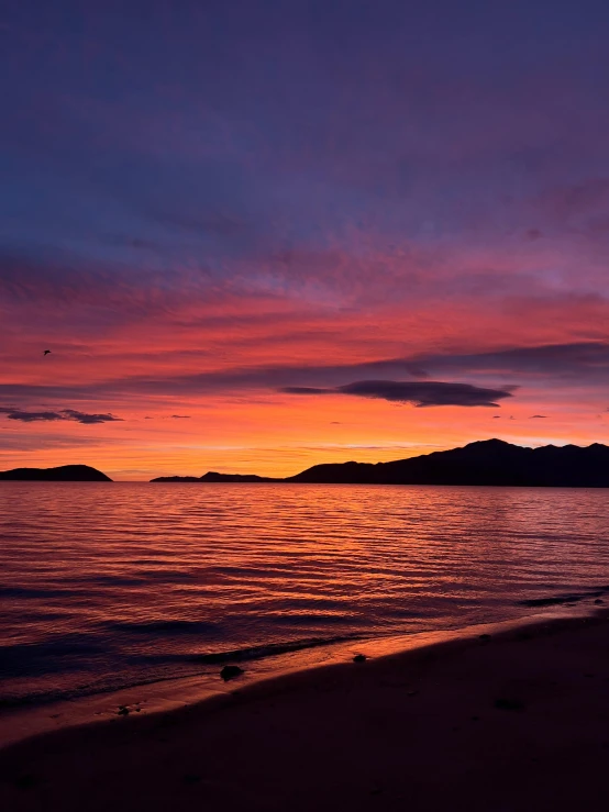 a sunset over a body of water at the beach