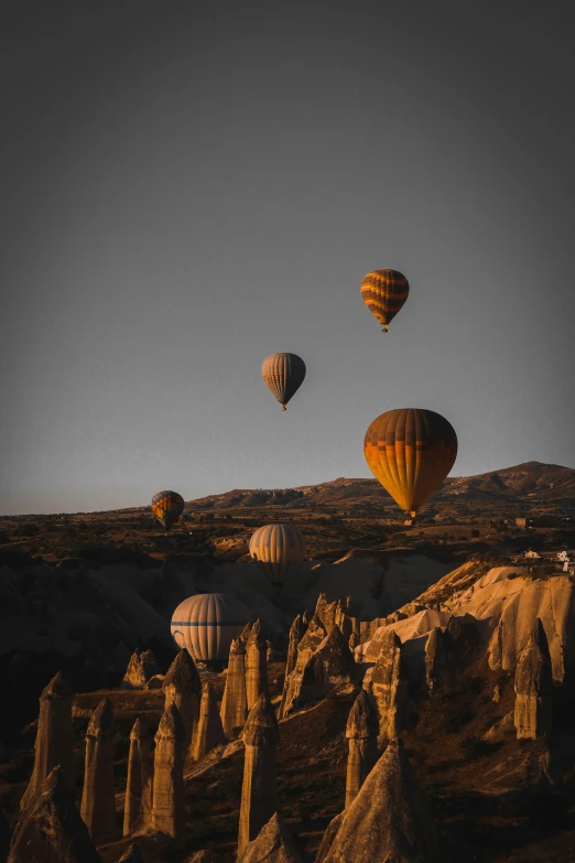 several  air balloons flying over an arid area