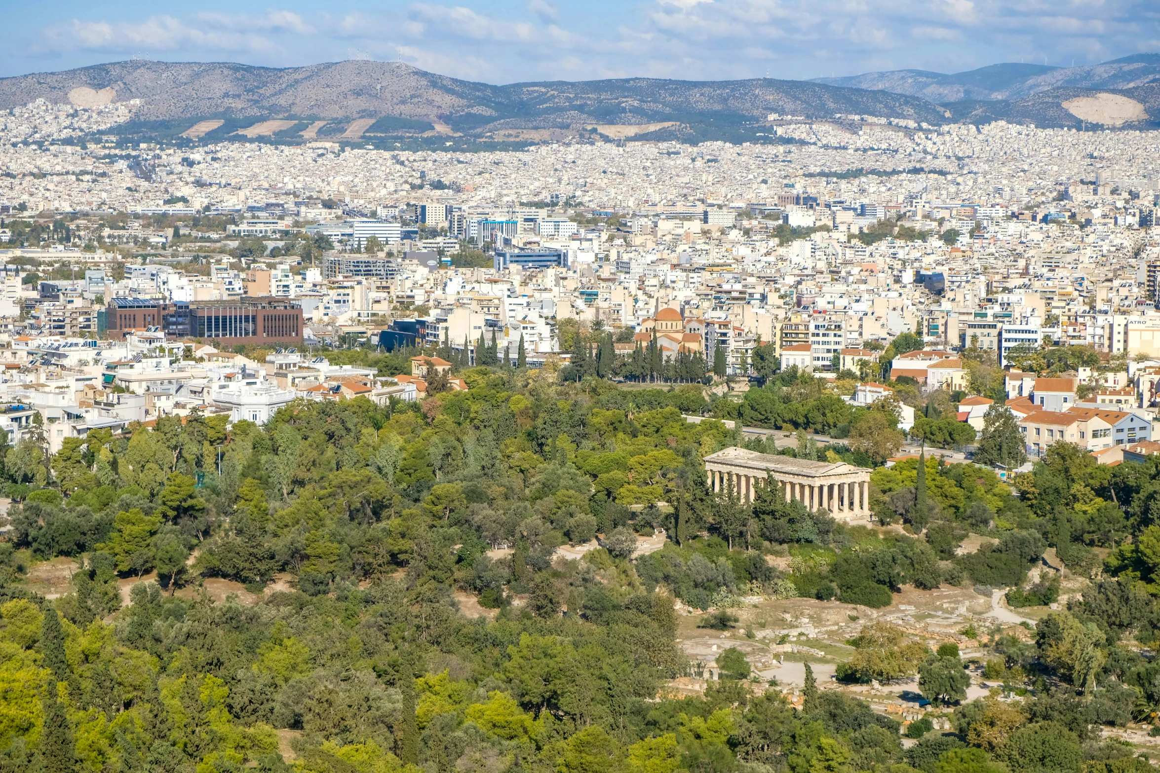 a city with tall buildings next to many trees