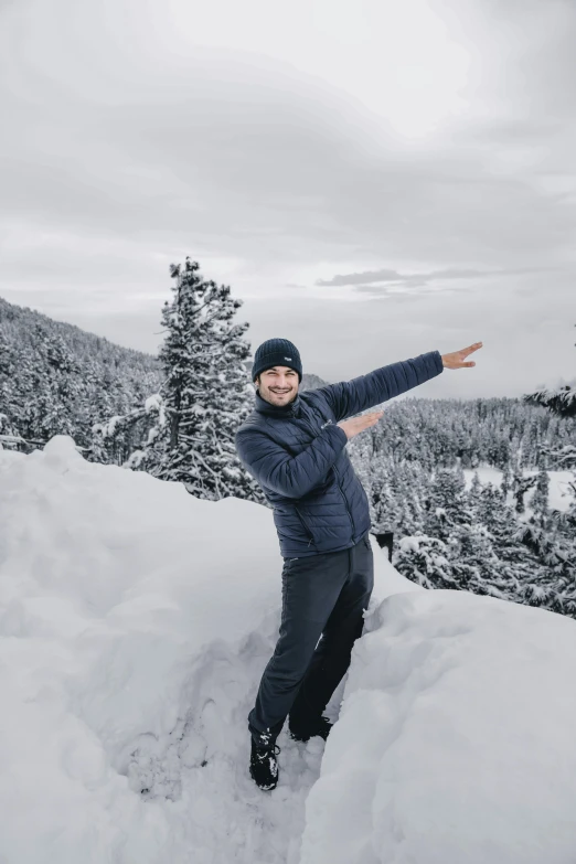 smiling person in dark blue jacket on snow covered mountain