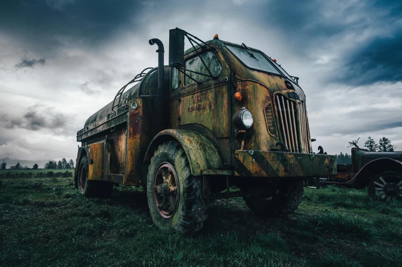 an old green transport truck sitting in a field