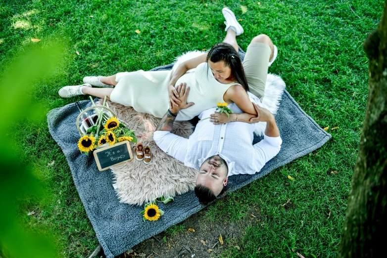 a man laying on the ground next to a women holding his baby