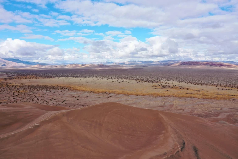 a brown desert area with several hills in the background