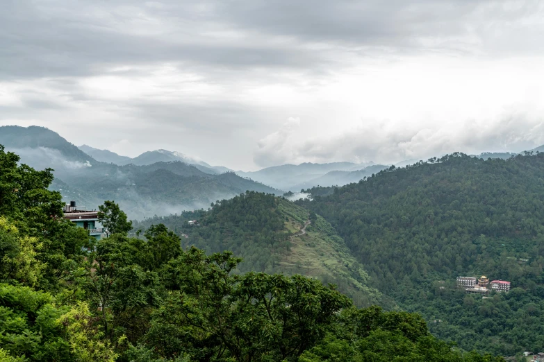 green mountains with trees and cloudy sky