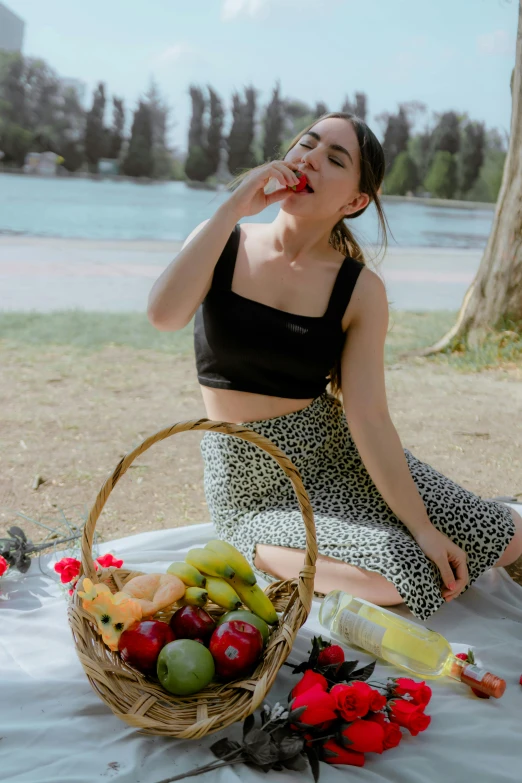 a woman sitting on the ground near a basket of fruit