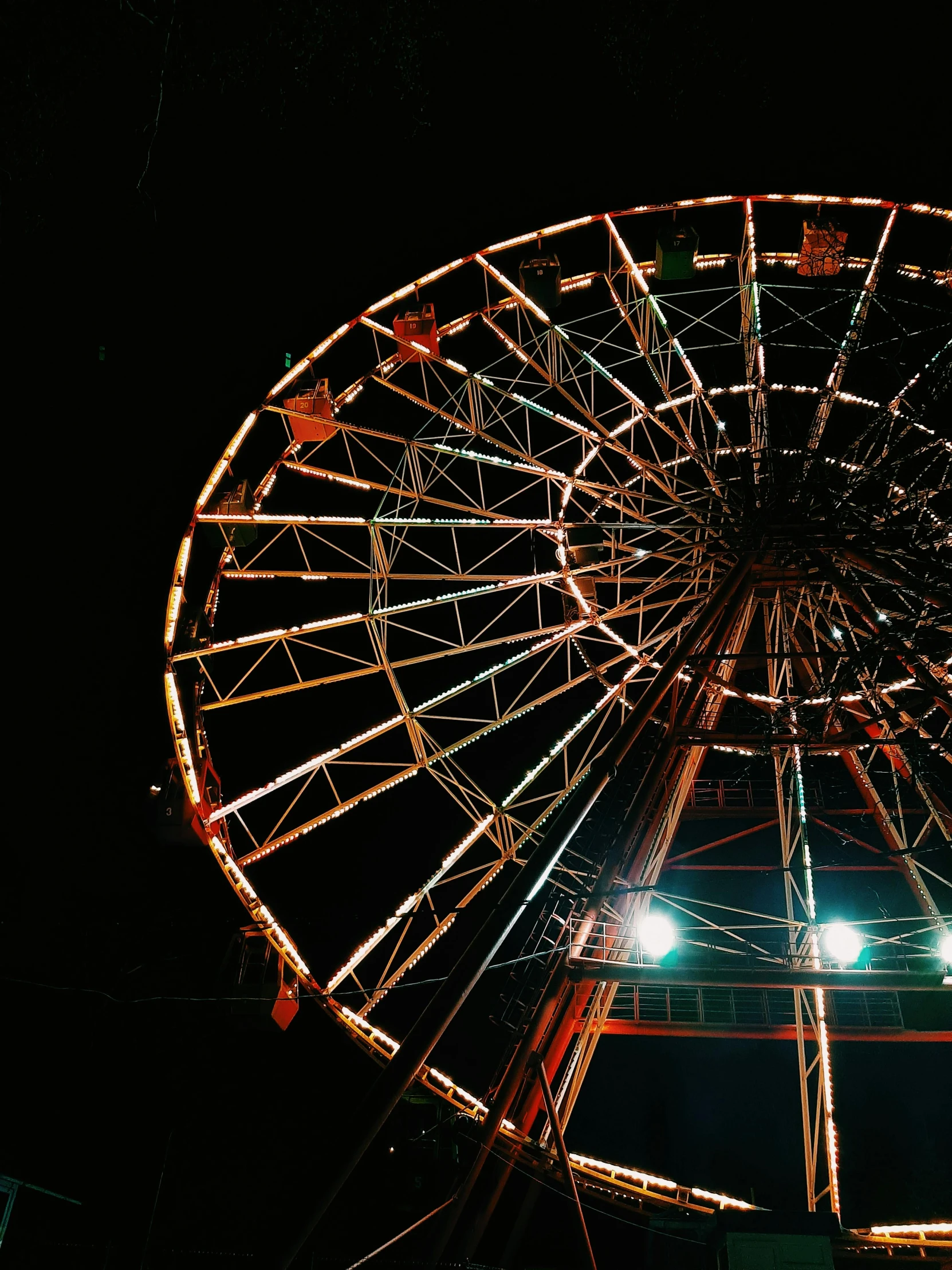 an ferris wheel is illuminated at night under the stars