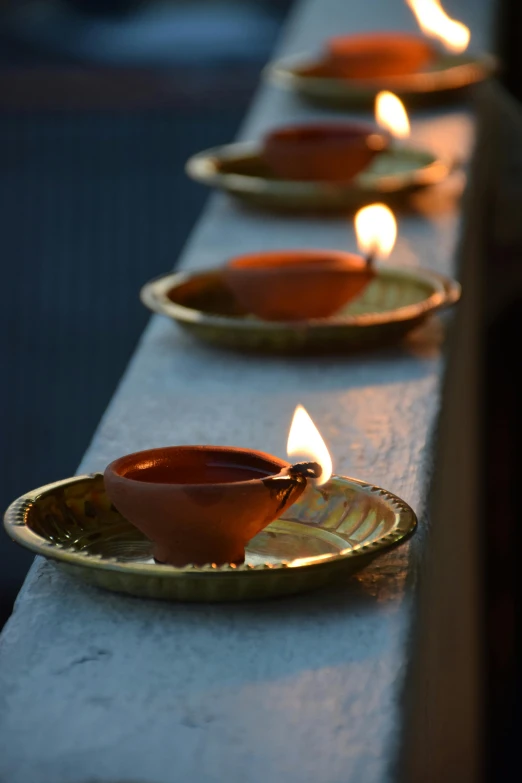 lit candles on plates line the back edge of a bar