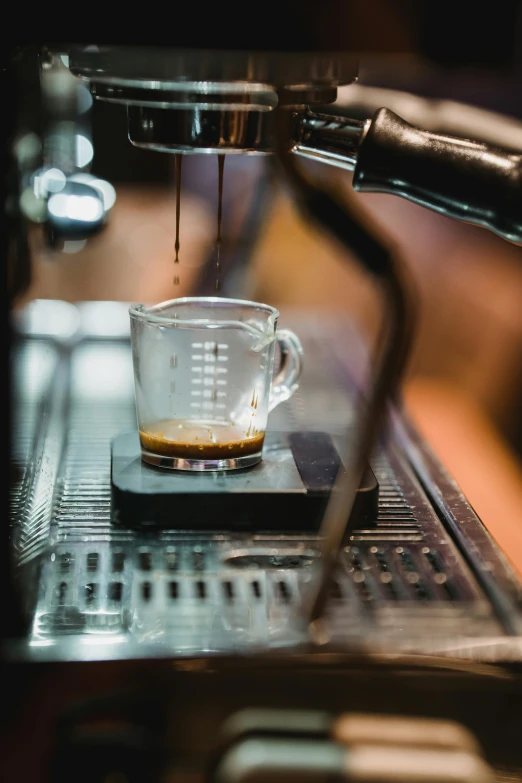 a coffee machine that has a glass cup