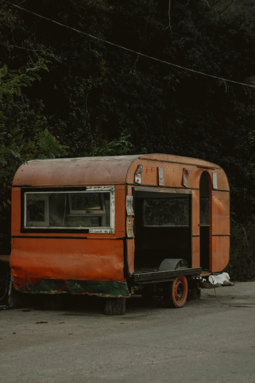 a rusted out bus parked in front of some bushes