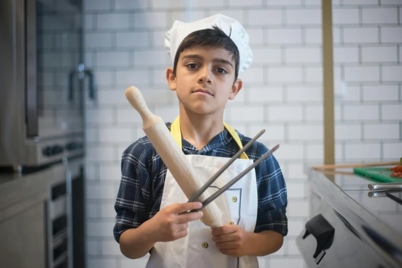 the  is using a pair of kitchen tongs to hold up an empty breadstick