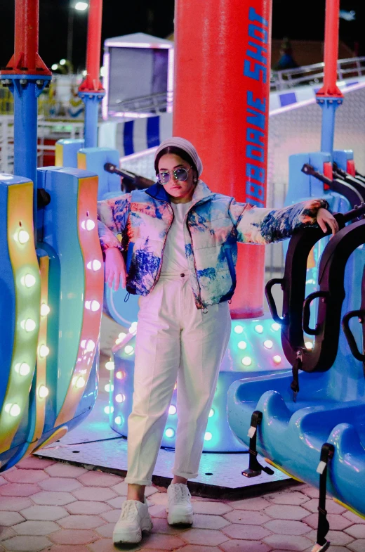 a woman standing in front of a carnival ride