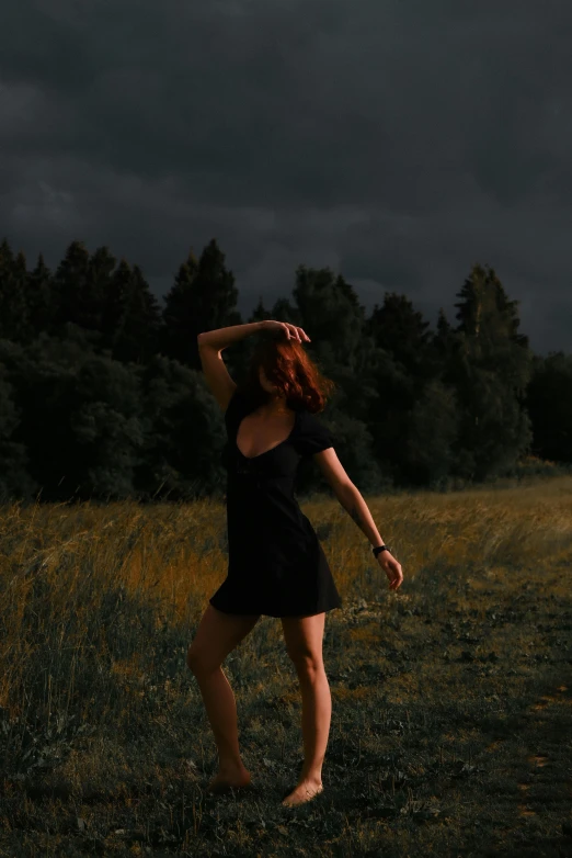 the woman standing in the grass is reaching up to the sky