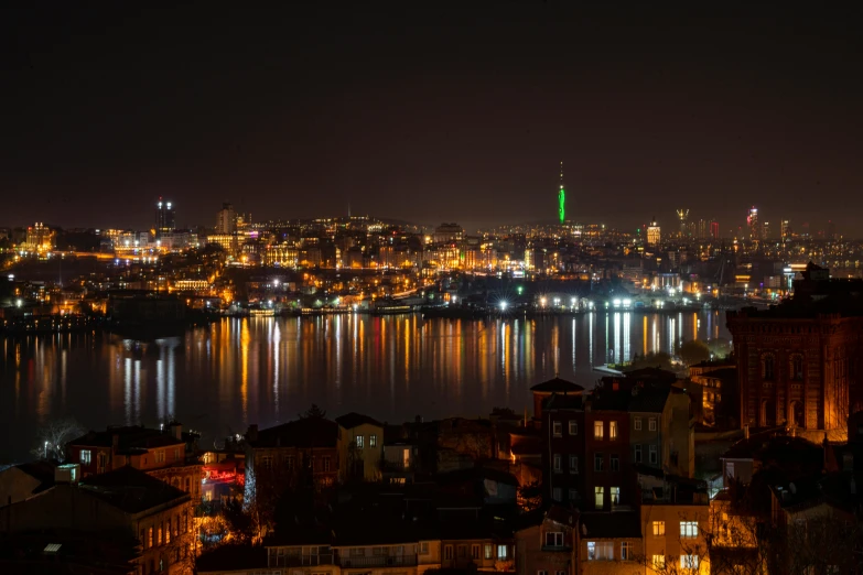 city skyline with a bright green building at night