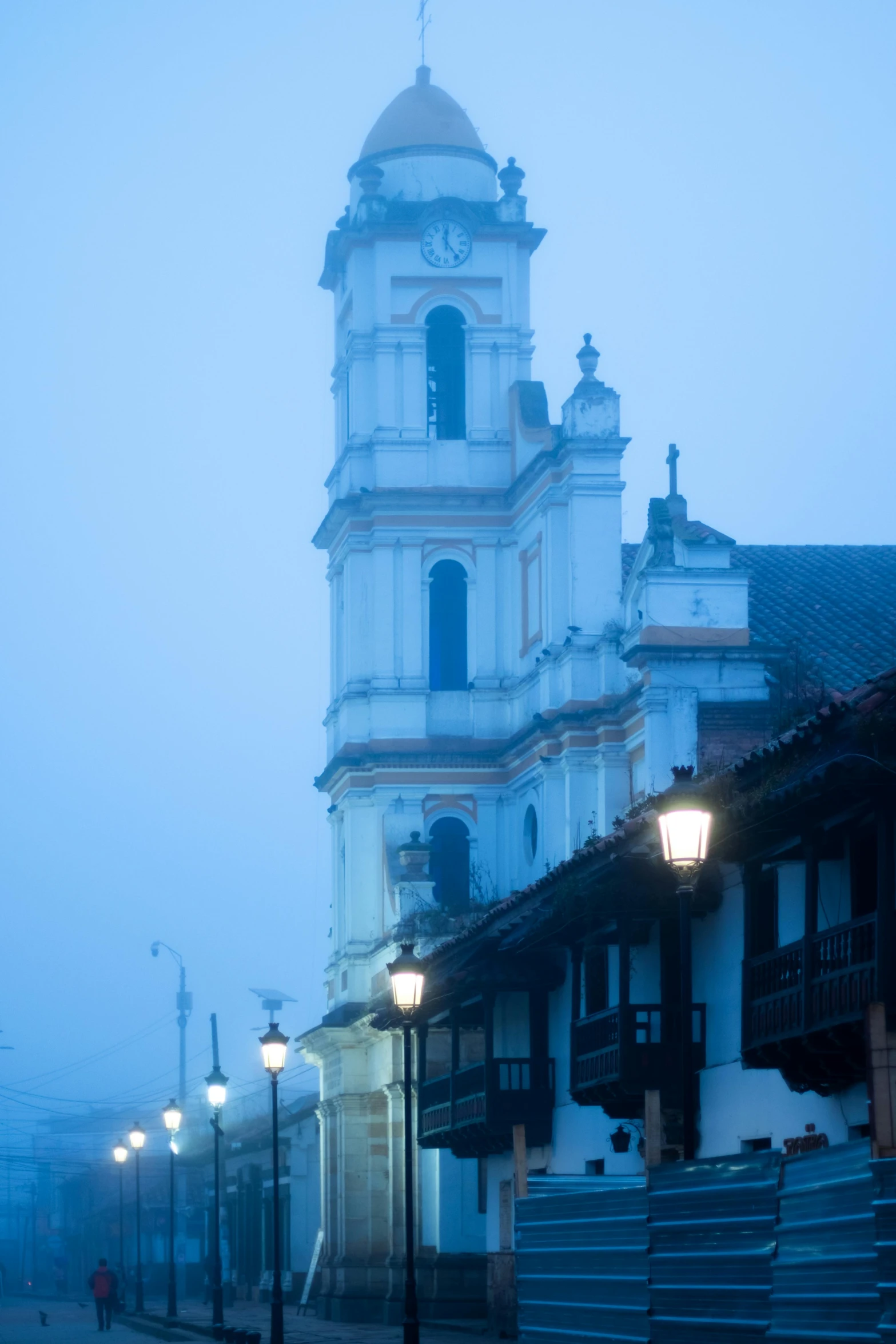 a church tower stands in the middle of some buildings