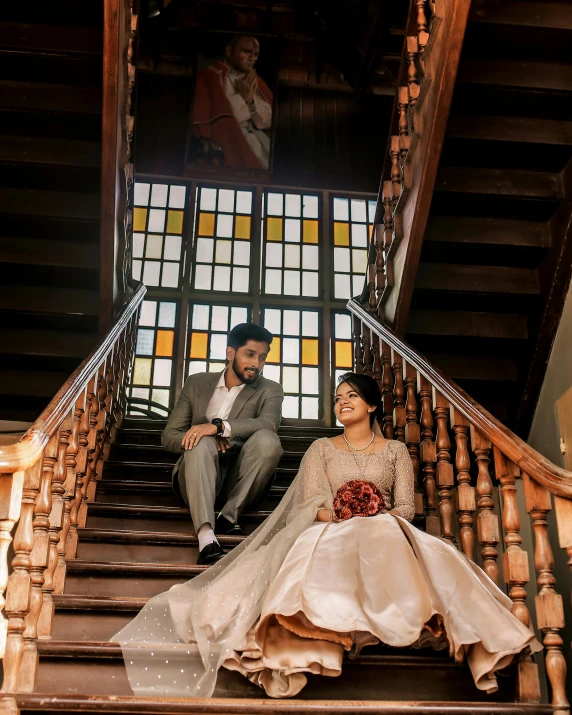 a couple is sitting down on some stairs together