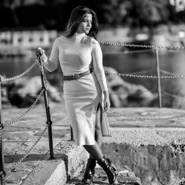 a woman in tight clothing stands next to some ropes