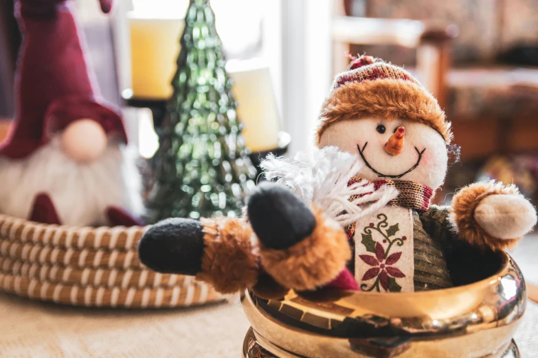 a snowman sitting in a holiday gift basket